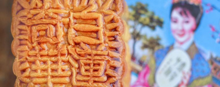 A square mooncake with intricate patterns and Chinese characters on its surface.