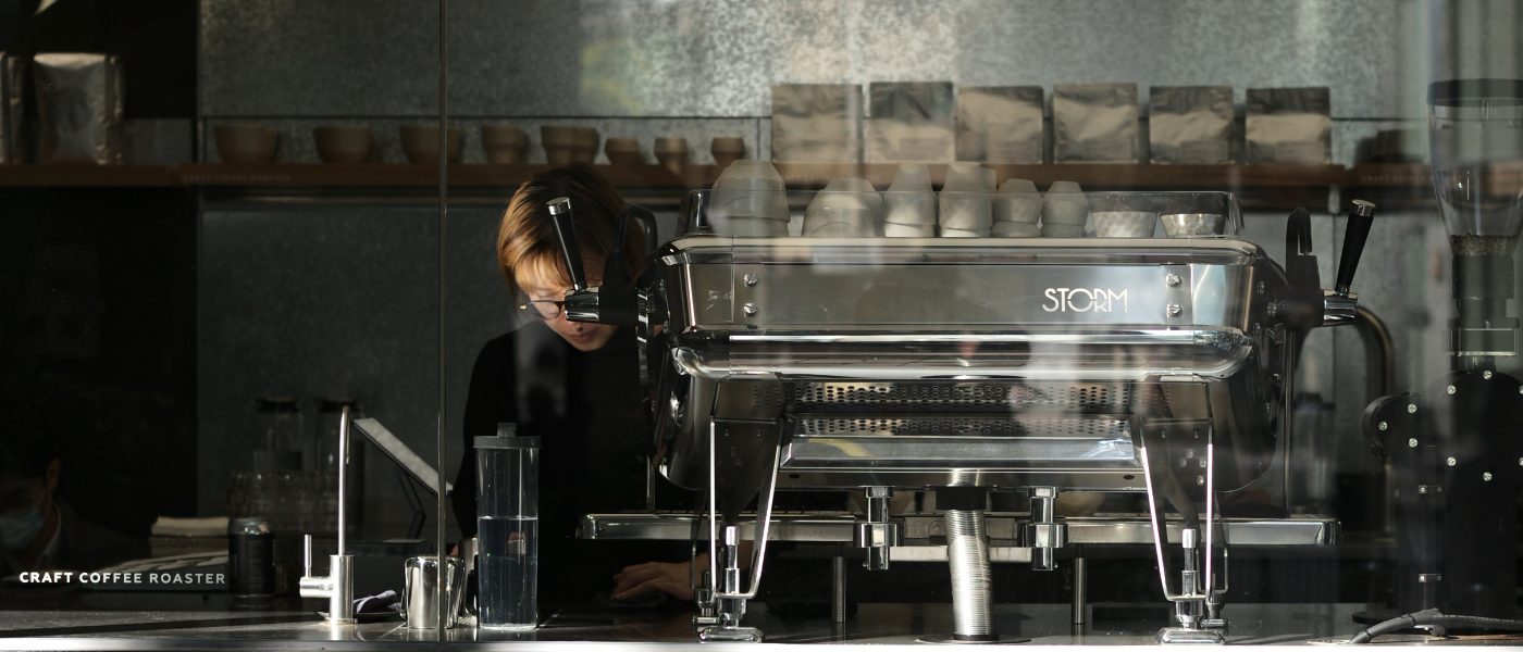 Barista operating a coffee machine at Craft Coffee Roaster in Hong Kong.